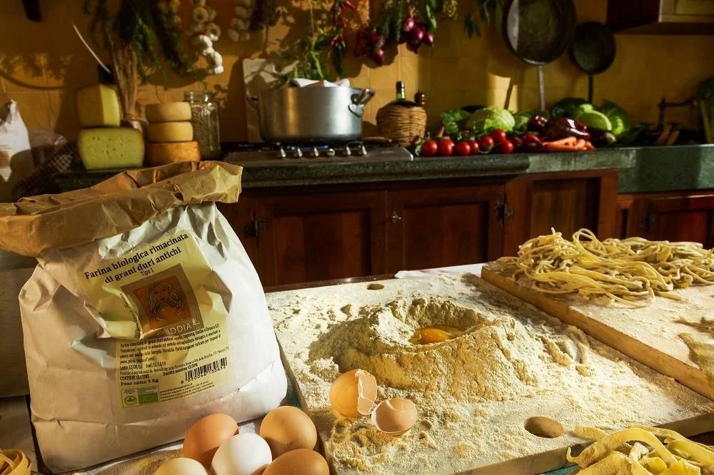 Il banco della cucina con farina biologica, uova fresche e tagliolini appena tirati