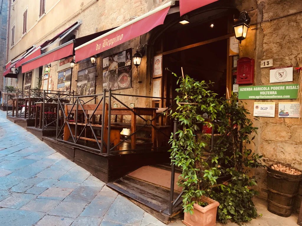 L'ingresso del ristorante in Via delle Prigioni, con le tende rosse e la porta ad arco in pietra